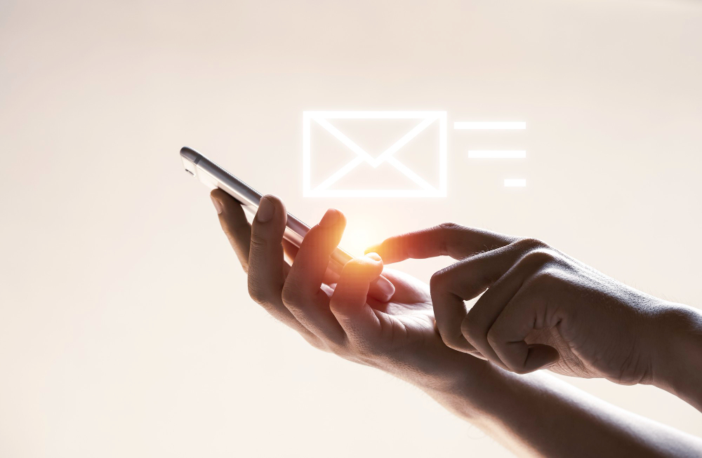 mano e icono de carta virtual sujetando un móvil_ por qué rebotan los correos